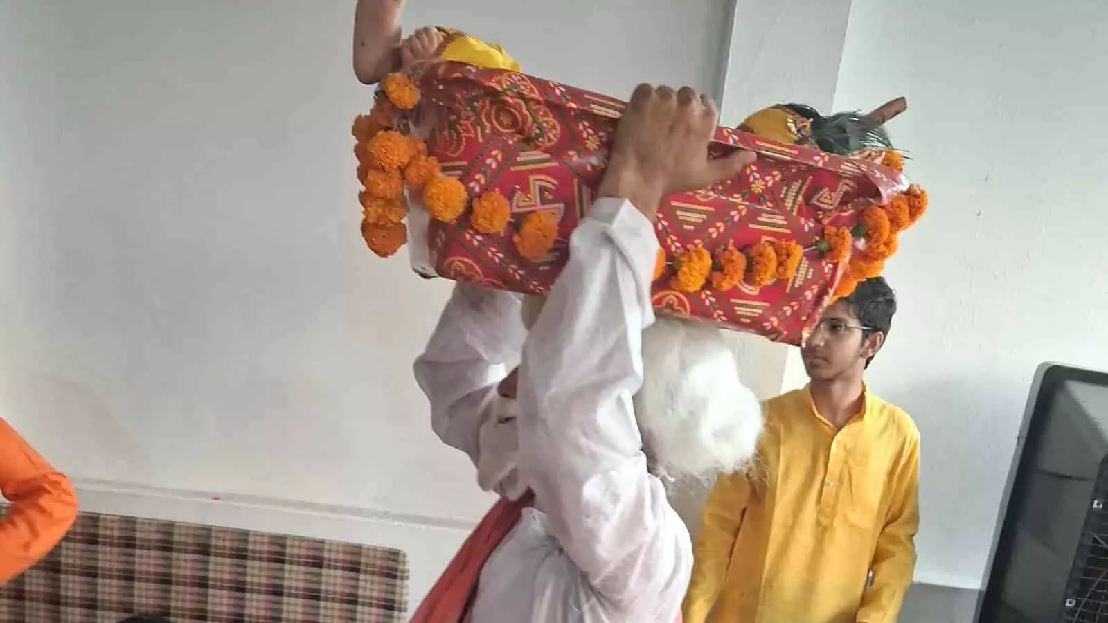 तस्वीर में एक व्यक्ति सिर पर टोकरी में बाल रूप भगवान श्री कृष्ण का स्वरूप उठाए हुए उत्सव मनाता दिख रहा है। तस्वीर में एक व्यक्ति सिर पर टोकरी में बाल रूप भगवान श्री कृष्ण का स्वरूप उठाए हुए उत्सव मनाता दिख रहा है।
