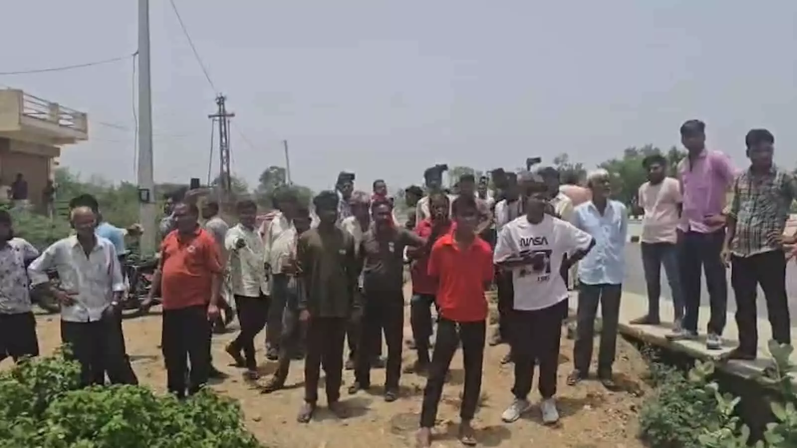 तस्वीर में सड़क किनारे बड़ी संख्या में ग्रामीण और आक्रोशित लोग विरोध प्रदर्शन के लिए खड़े हुए दिख रहे हैं। तस्वीर में सड़क किनारे बड़ी संख्या में ग्रामीण और आक्रोशित लोग विरोध प्रदर्शन के लिए खड़े हुए दिख रहे हैं।