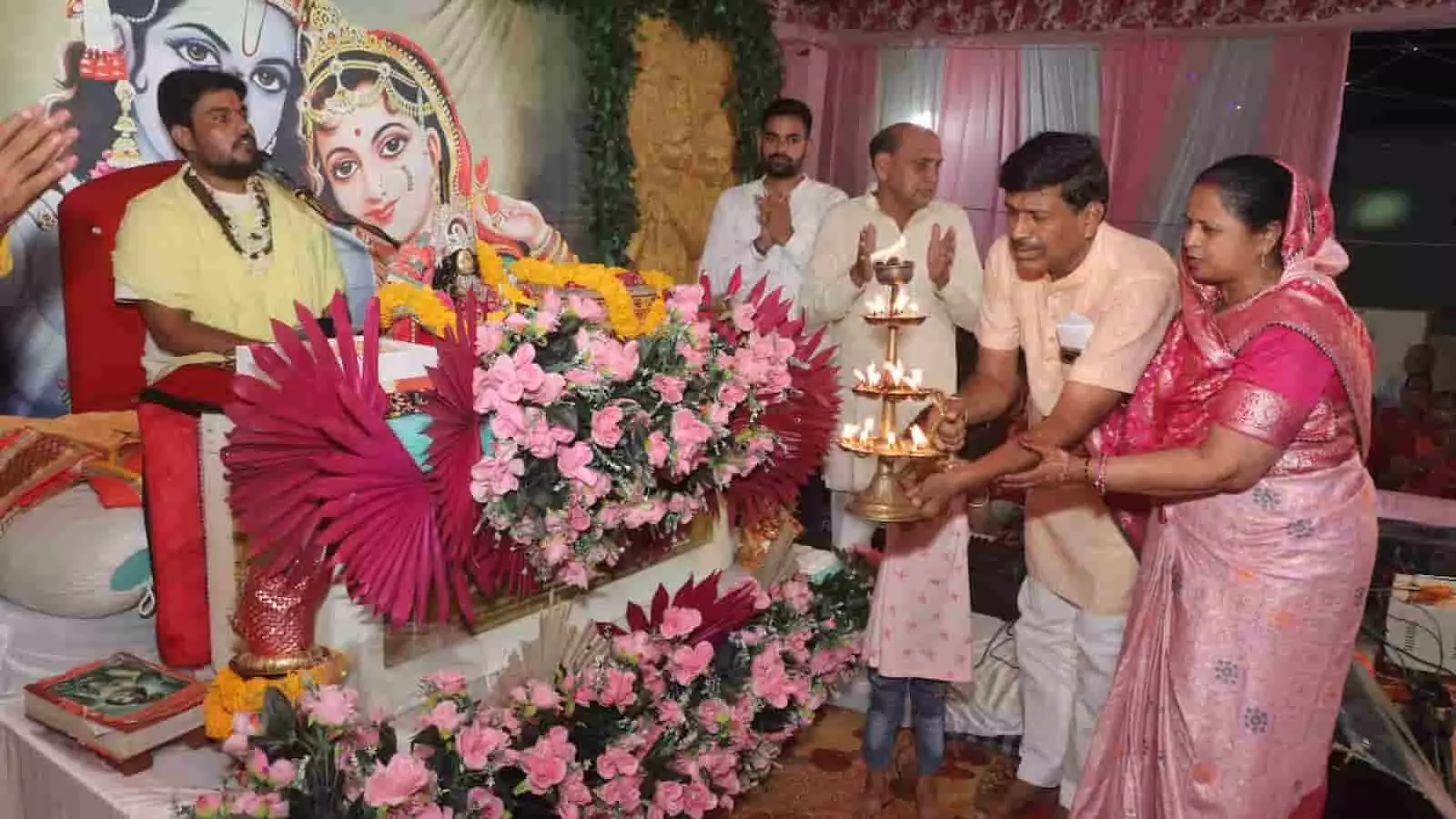 तस्वीर में एक सुसज्जित धार्मिक मंच (व्यासपीठ) पर कथावाचक बैठे हुए हैं और सामने दीवार पर श्री चारभुजा मंदिर पाटोत्सव महोत्सव का बैनर लगा है। तस्वीर में एक सुसज्जित धार्मिक मंच (व्यासपीठ) पर कथावाचक बैठे हुए हैं और सामने दीवार पर श्री चारभुजा मंदिर पाटोत्सव महोत्सव का बैनर लगा है।