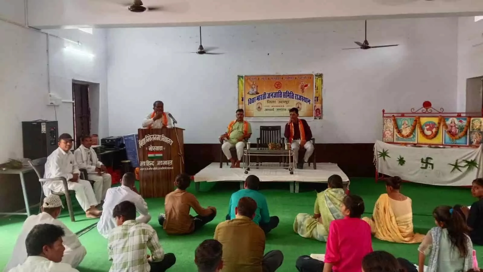 तस्वीर में एक बड़े हॉल के फर्श पर बिछी दरी पर कई पुरुष और महिला प्रशिक्षार्थी बैठे हुए हैं तथा सामने मंच पर वक्ता उपस्थित हैं। तस्वीर में एक बड़े हॉल के फर्श पर बिछी दरी पर कई पुरुष और महिला प्रशिक्षार्थी बैठे हुए हैं तथा सामने मंच पर वक्ता उपस्थित हैं।