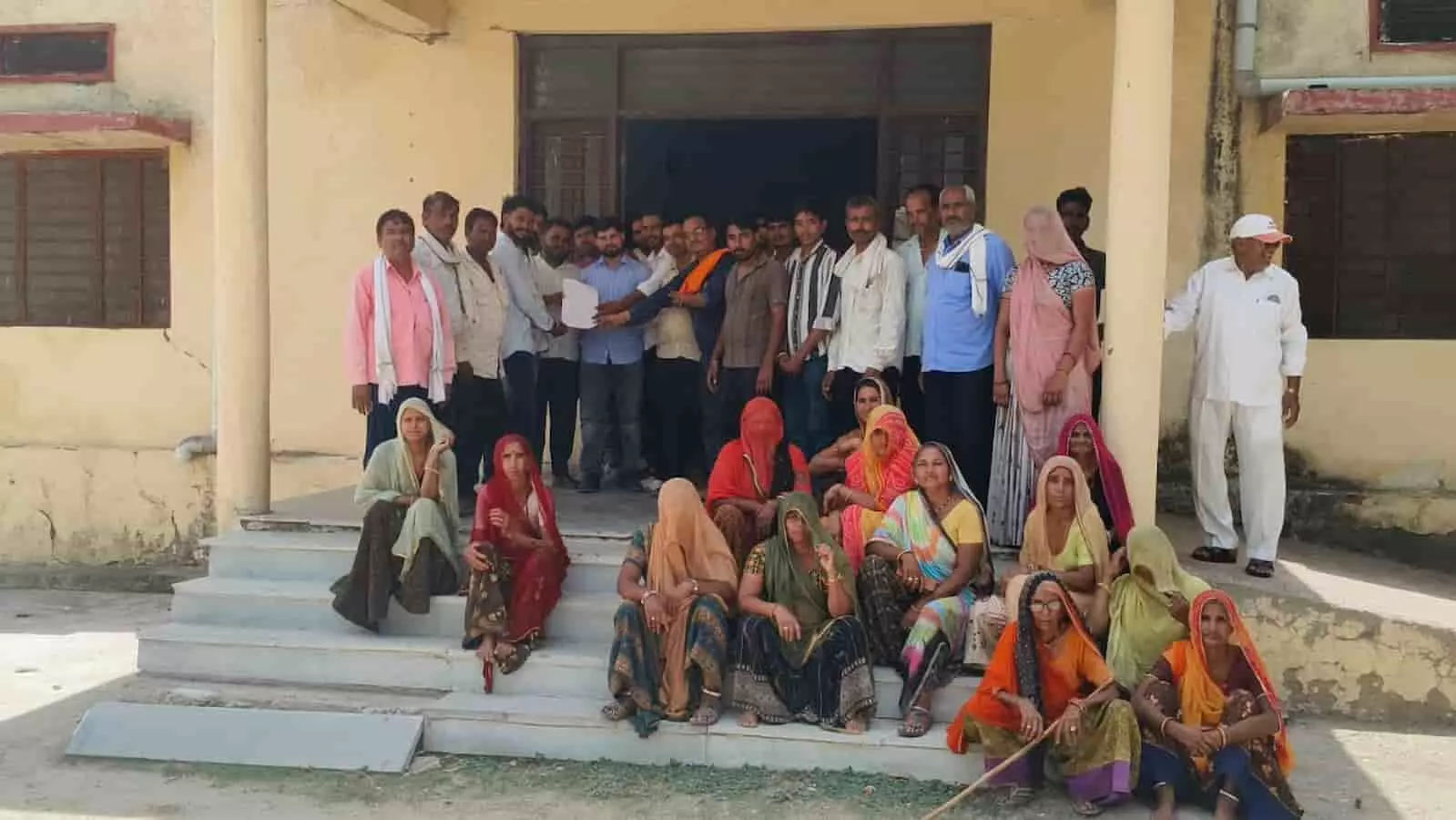 तस्वीर में पारी ग्राम पंचायत के पुरुष और महिलाएं एक सरकारी भवन के बाहर ज्ञापन सौंपकर खड़े हुए दिख रहे हैं। तस्वीर में पारी ग्राम पंचायत के पुरुष और महिलाएं एक सरकारी भवन के बाहर ज्ञापन सौंपकर खड़े हुए दिख रहे हैं।