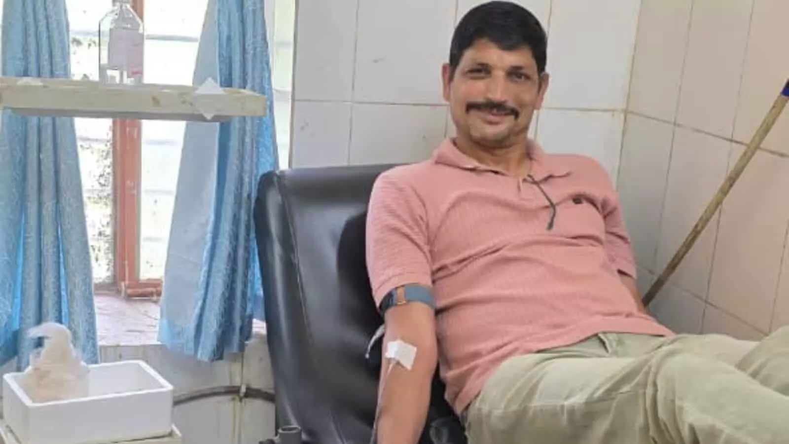 तस्वीर में अस्पताल के एक वार्ड के भीतर बेड पर लेटे हुए एक व्यक्ति मुस्कुराते हुए रक्तदान कर रहे हैं और उनके पास एक अन्य व्यक्ति खड़ा दिखाई दे रहा है। तस्वीर में अस्पताल के एक वार्ड के भीतर बेड पर लेटे हुए एक व्यक्ति मुस्कुराते हुए रक्तदान कर रहे हैं और उनके पास एक अन्य व्यक्ति खड़ा दिखाई दे रहा है।