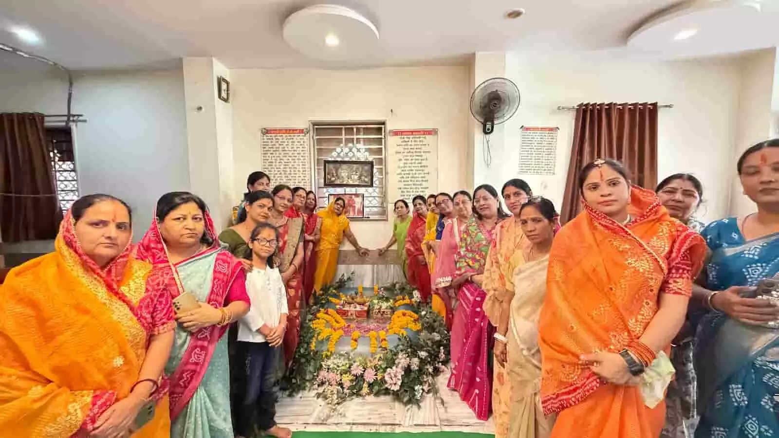 तस्वीर में पारंपरिक पोशाक और आभूषण पहने कई महिलाएं एक छोटे कृत्रिम जलकुंड के पास बैठकर पूजा-अर्चना और भजनों का आनंद लेती हुई दिखाई दे रही हैं। तस्वीर में पारंपरिक पोशाक और आभूषण पहने कई महिलाएं एक छोटे कृत्रिम जलकुंड के पास बैठकर पूजा-अर्चना और भजनों का आनंद लेती हुई दिखाई दे रही हैं।