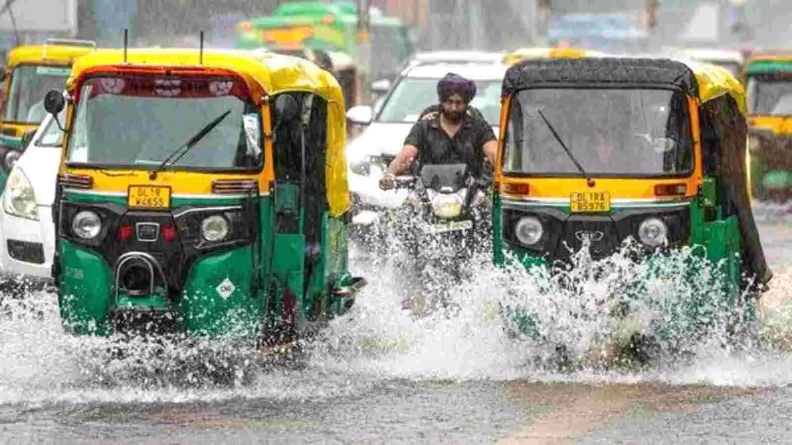 बारिश के पानी से भरी सड़क पर चलते हुए हरे और पीले रंग के ऑटो रिक्शा और मोटरसाइकिल सवार व्यक्ति बारिश के पानी से भरी सड़क पर चलते हुए हरे और पीले रंग के ऑटो रिक्शा और मोटरसाइकिल सवार व्यक्ति