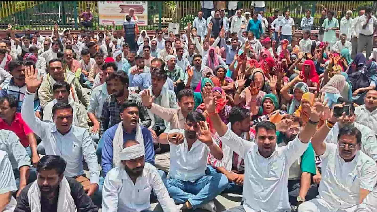 भीलवाड़ा जिला कलेक्ट्रेट के बाहर जमीन पर बैठकर नारेबाजी और प्रदर्शन करते बलाई समाज के सैकड़ों लोग।