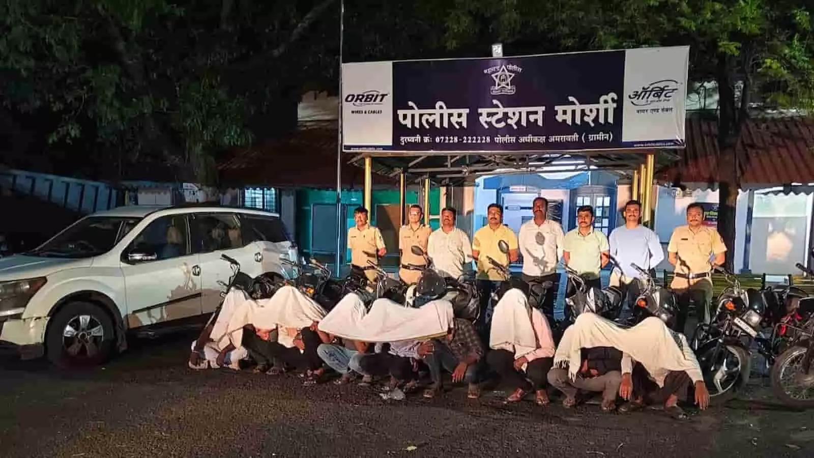 तस्वीर में मोर्शी पुलिस स्टेशन के बाहर पकड़े गए 12 आरोपी और जब्त वाहन दिख रहे हैं।