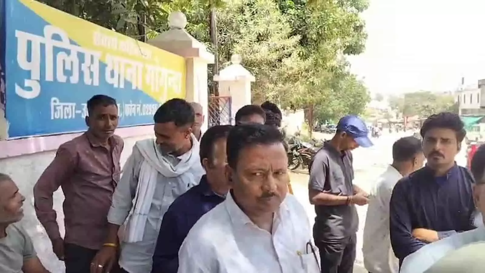 गोगुंदा पुलिस थाना के बोर्ड के सामने खड़े होकर प्रदर्शन करते हुए ग्रामीण पुरुष। गोगुंदा पुलिस थाना के बोर्ड के सामने खड़े होकर प्रदर्शन करते हुए ग्रामीण पुरुष।