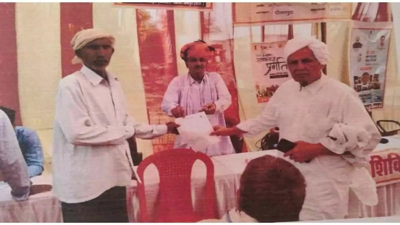 ग्रामीण सेवा शिविर में अधिकारी ग्रामीण व्यक्ति को सामाजिक सुरक्षा पेंशन का स्वीकृति पत्र सौंपते हुए। ग्रामीण सेवा शिविर में अधिकारी ग्रामीण व्यक्ति को सामाजिक सुरक्षा पेंशन का स्वीकृति पत्र सौंपते हुए।