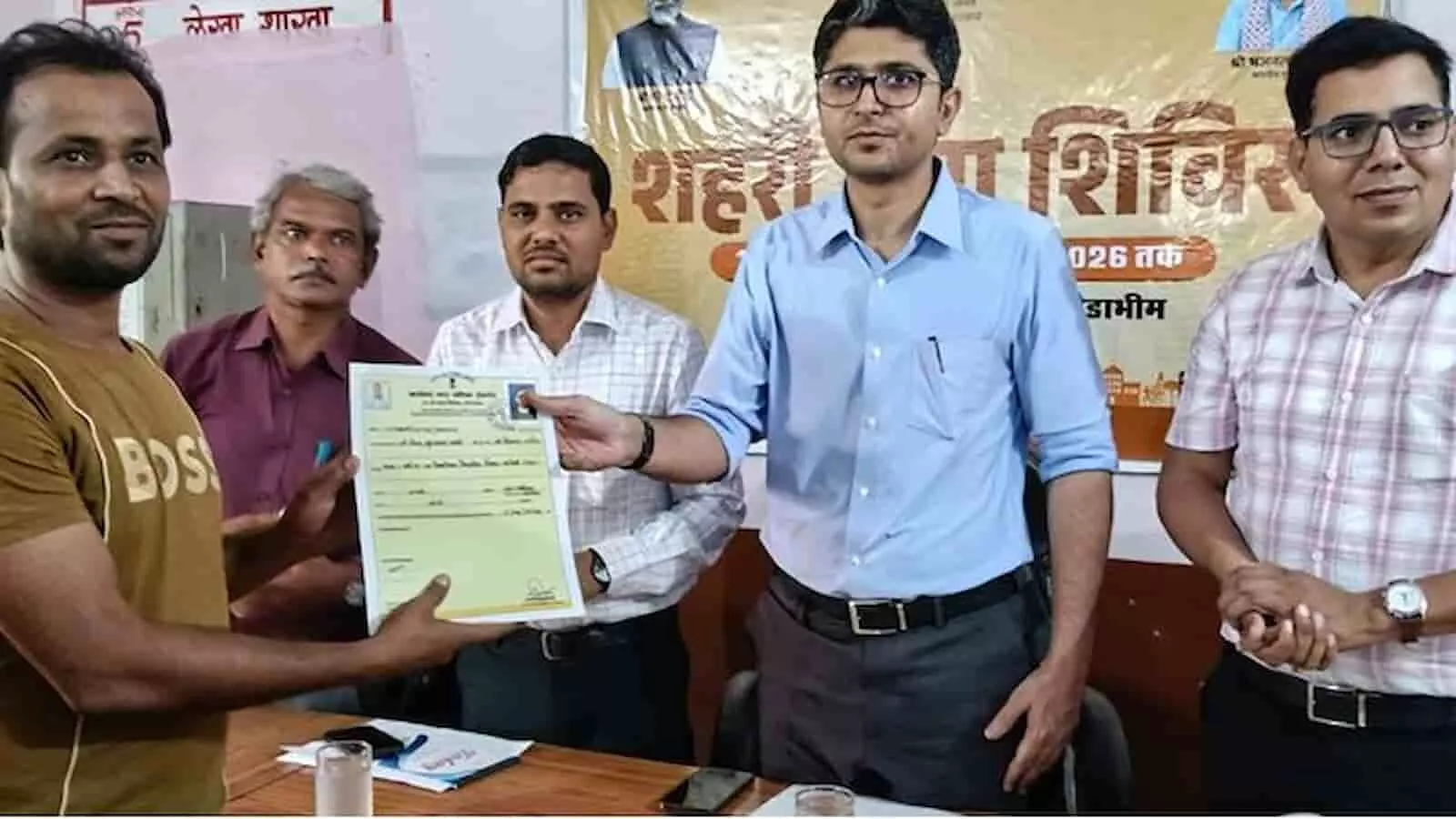 तस्वीर में अधिकारी टोडाभीम शिविर में निवासी सयैद मुजफ्फर को आवासीय पट्टा सौंप रहे हैं।