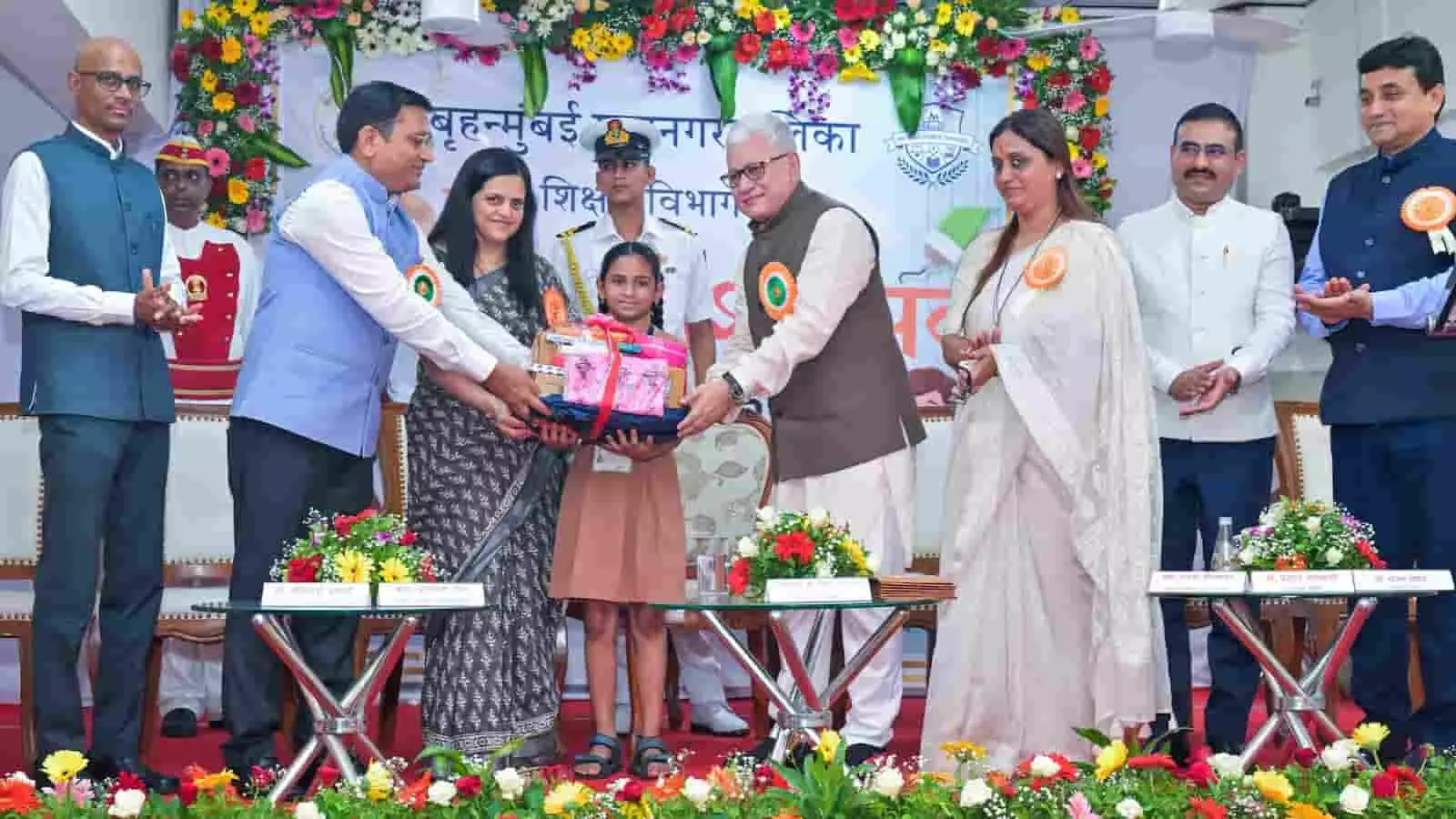 भायखला के बीएमसी स्कूल में प्रवेशोत्सव के दौरान एक छात्रा को पुस्तक और उपहार देते अतिथिगण। भायखला के बीएमसी स्कूल में प्रवेशोत्सव के दौरान एक छात्रा को पुस्तक और उपहार देते अतिथिगण।