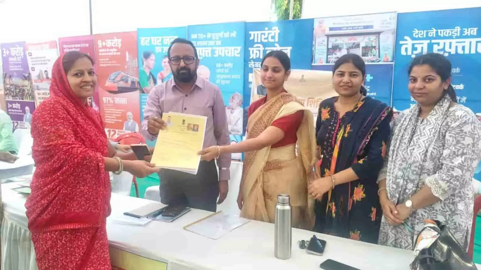 सवाई माधोपुर नगर परिषद कार्यालय में शहरी सेवा शिविर के दौरान महिला को दस्तावेज सौंपते अधिकारी और कर्मचारी। सवाई माधोपुर नगर परिषद कार्यालय में शहरी सेवा शिविर के दौरान महिला को दस्तावेज सौंपते अधिकारी और कर्मचारी।