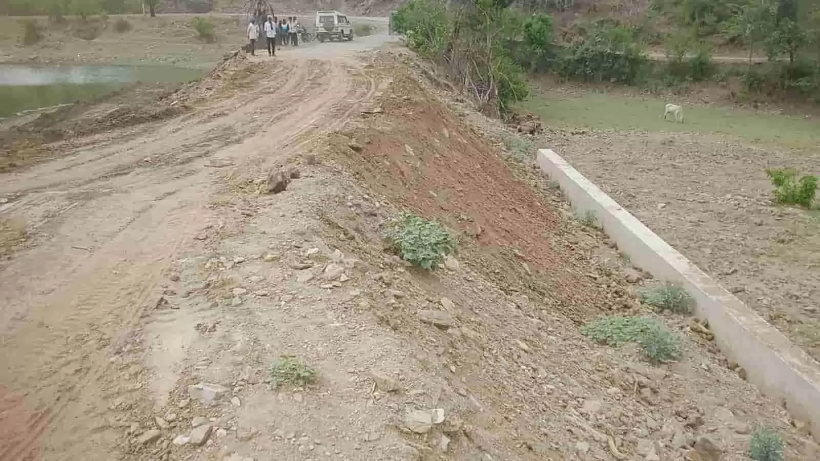 काटवी गांव के पास एक ऊंचे मिट्टी के बांधनुमा रास्ते पर खड़ी गाड़ी और खड़े हुए कुछ ग्रामीण। काटवी गांव के पास एक ऊंचे मिट्टी के बांधनुमा रास्ते पर खड़ी गाड़ी और खड़े हुए कुछ ग्रामीण।