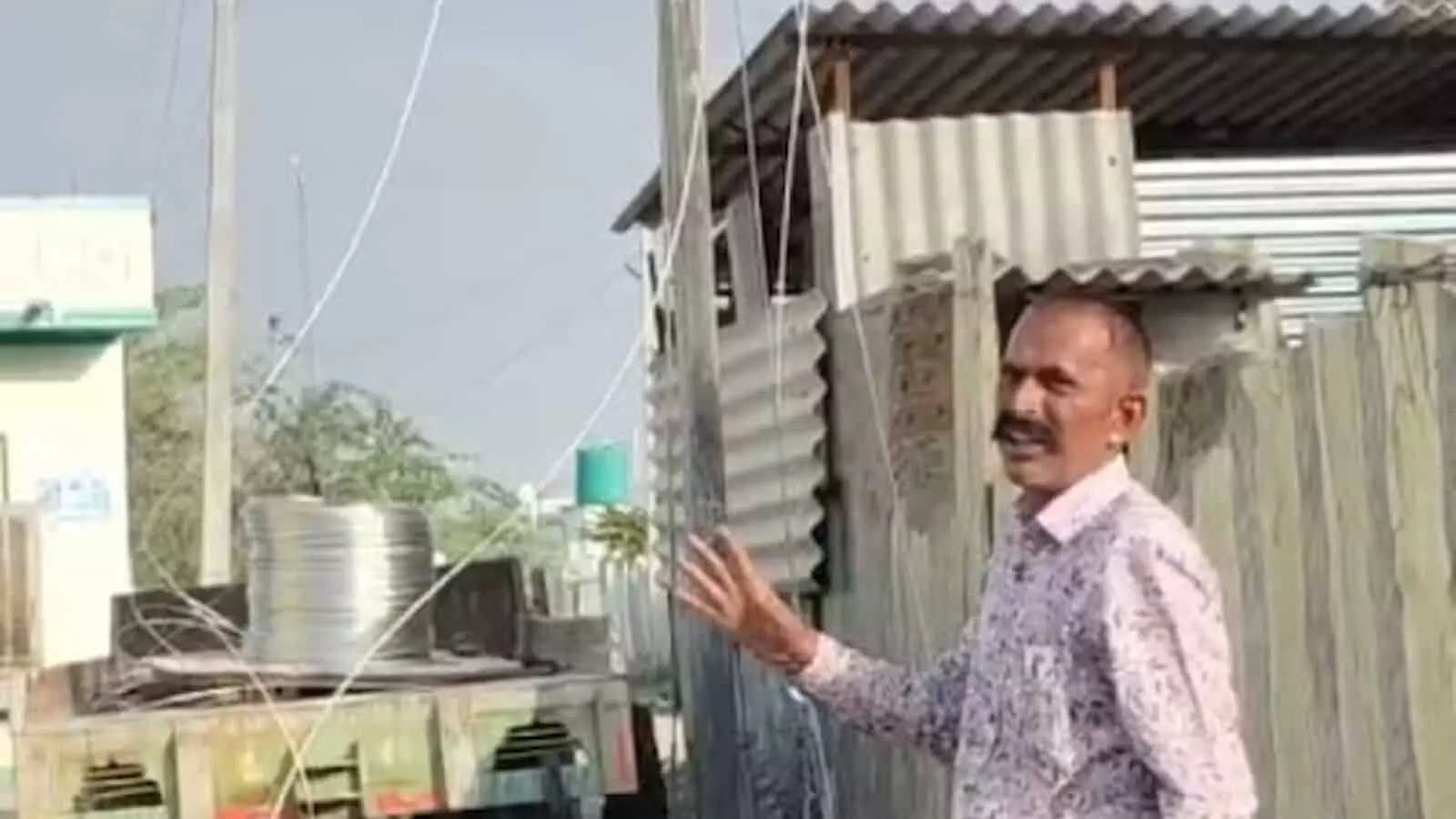 रायपुर के कपूड़ी ढाणी में बिजली पोल के पास खड़ा एक ग्रामीण व्यक्ति हाथ से इशारा करते हुए विद्युत सुधार कार्य का विवरण दे रहा है। रायपुर के कपूड़ी ढाणी में बिजली पोल के पास खड़ा एक ग्रामीण व्यक्ति हाथ से इशारा करते हुए विद्युत सुधार कार्य का विवरण दे रहा है।