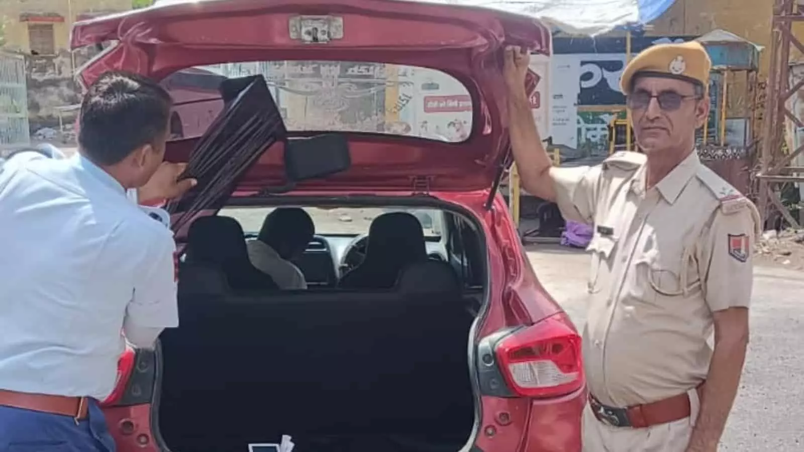जयपुर में कार की खिड़की से काली फिल्म हटाते पुलिसकर्मी और सुरक्षा व्यवस्था सुनिश्चित करते यातायात पुलिस अधिकारी।