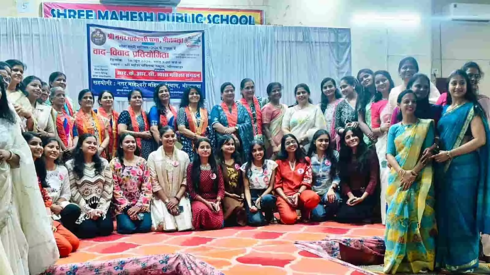 भीलवाड़ा के श्री महेश पब्लिक स्कूल में वाद-विवाद प्रतियोगिता के बैनर के सामने खड़ी प्रतिभागी और आयोजक महिलाएं। भीलवाड़ा के श्री महेश पब्लिक स्कूल में वाद-विवाद प्रतियोगिता के बैनर के सामने खड़ी प्रतिभागी और आयोजक महिलाएं।