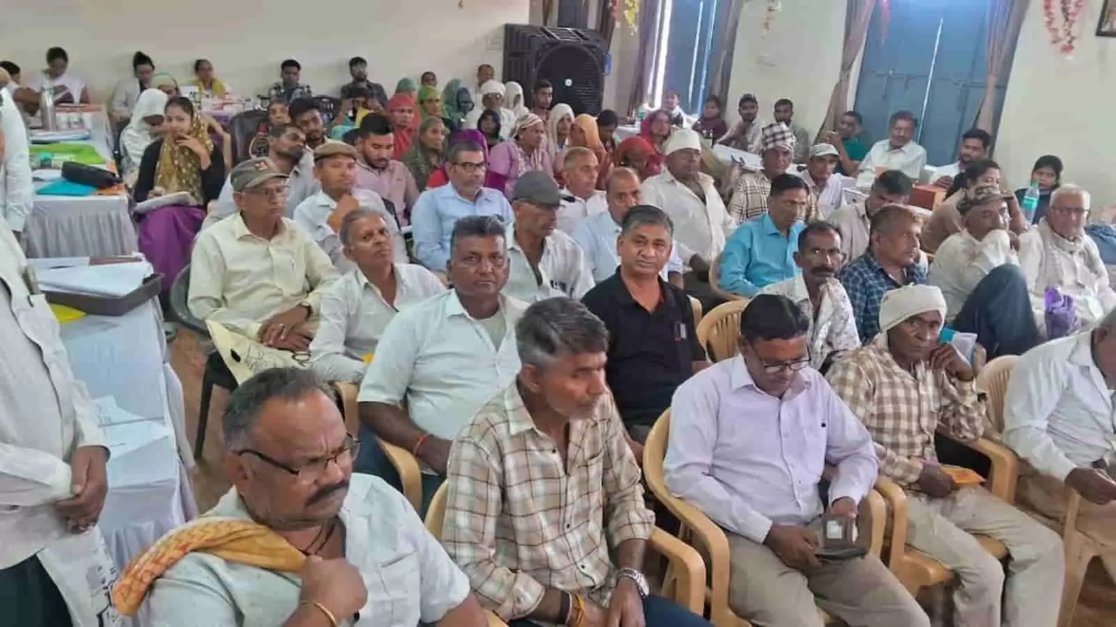ग्राम पंचायत पलसिया में ग्रामीण सेवा शिविर के दौरान समस्याओं के समाधान के लिए कुर्सियों पर बैठे ग्रामीण पुरुष और महिलाएं। ग्राम पंचायत पलसिया में ग्रामीण सेवा शिविर के दौरान समस्याओं के समाधान के लिए कुर्सियों पर बैठे ग्रामीण पुरुष और महिलाएं।