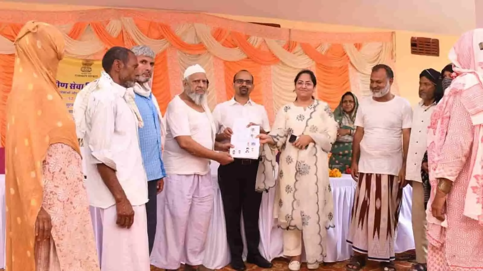 सवाई माधोपुर के सूरवाल ग्रामीण सेवा शिविर में अधिकारियों द्वारा ग्रामीणों को जमीन के मालिकाना हक का दस्तावेज सौंपते हुए दृश्य।