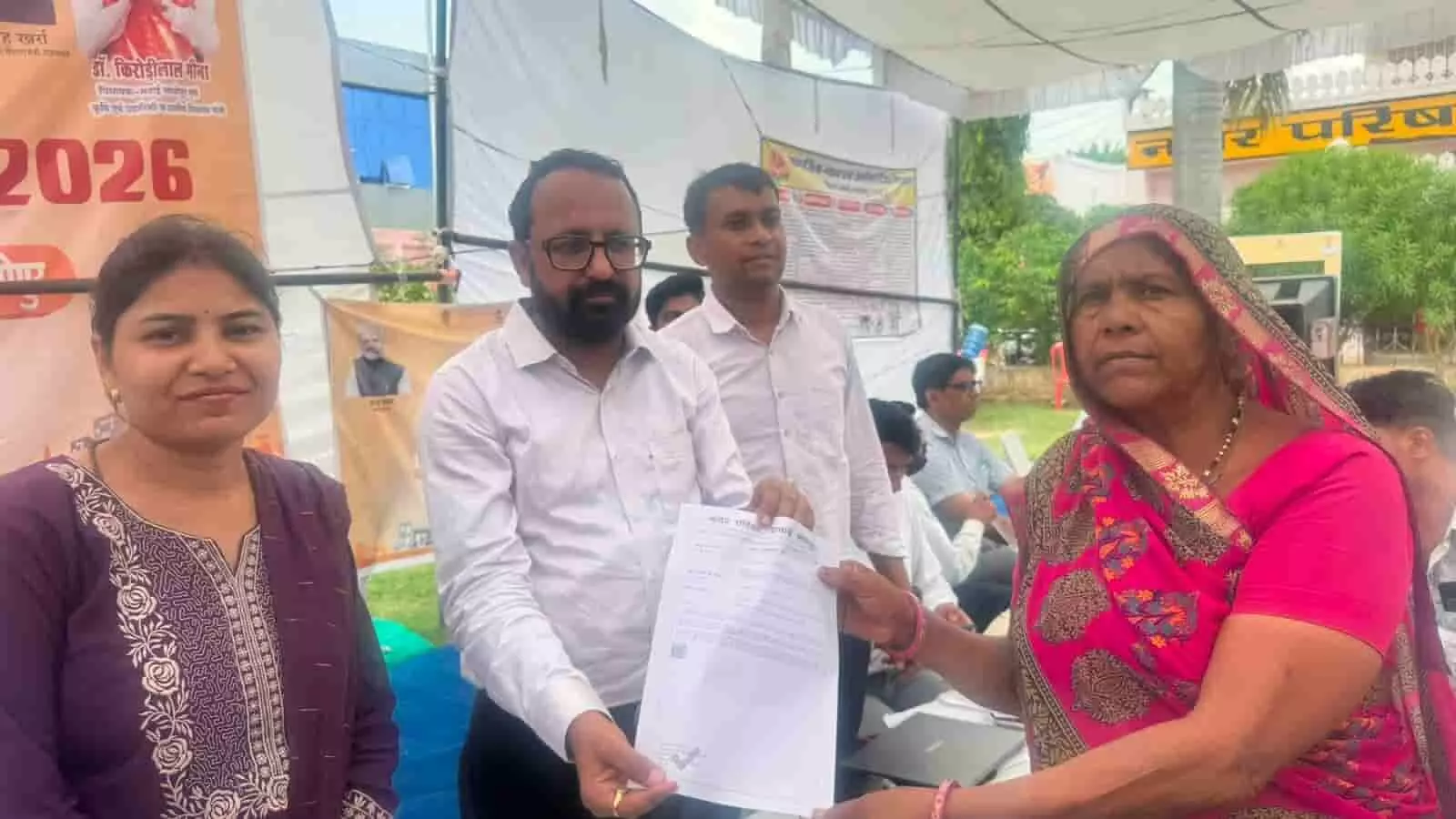 तस्वीर में नगर परिषद आयुक्त लाभार्थियों को प्रमाण पत्र देते हुए नजर आ रहे हैं।