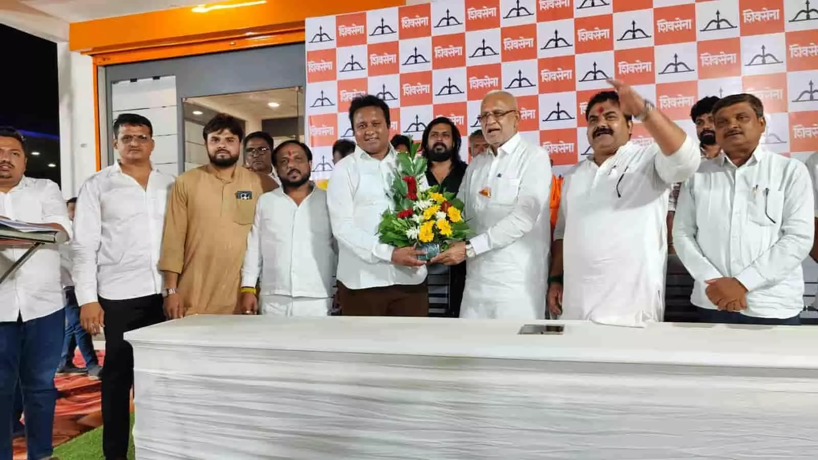 शिरपुर में शिवसेना शिंदे गुट के कार्यकर्ता सम्मेलन के दौरान मंच पर नेताओं द्वारा गुलदस्ता भेंट करने का दृश्य। शिरपुर में शिवसेना शिंदे गुट के कार्यकर्ता सम्मेलन के दौरान मंच पर नेताओं द्वारा गुलदस्ता भेंट करने का दृश्य।