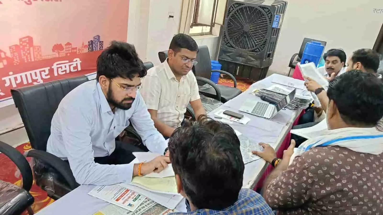 गंगापुर सिटी के नगर परिषद सभागार में शहरी सेवा शिविर के दौरान अधिकारियों और नागरिकों के बीच चल रही प्रशासनिक बैठक। गंगापुर सिटी के नगर परिषद सभागार में शहरी सेवा शिविर के दौरान अधिकारियों और नागरिकों के बीच चल रही प्रशासनिक बैठक।