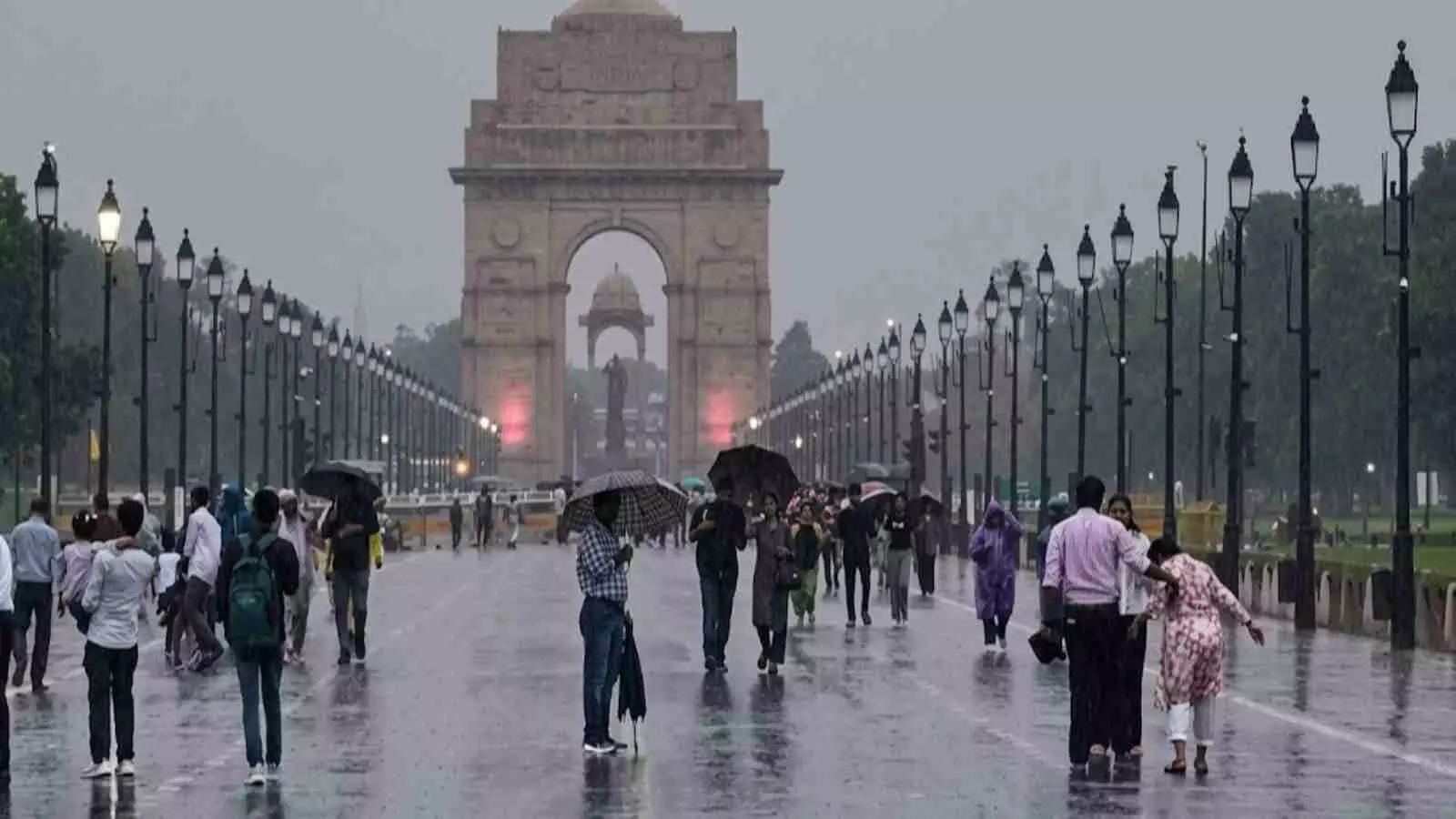 बारिश के बीच इंडिया गेट के पास सड़कों पर चलते हुए लोग। बारिश के बीच इंडिया गेट के पास सड़कों पर चलते हुए लोग।