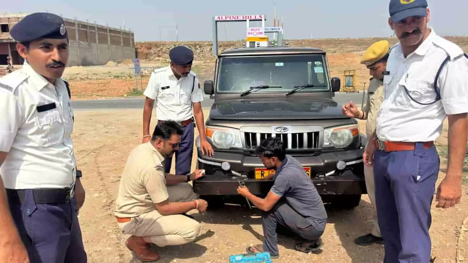 सैलंबर में सड़क किनारे खड़े वाहन की नंबर प्लेट बदलते पुलिसकर्मी और मैकेनिक यातायात अभियान के संदर्भ में। सैलंबर में सड़क किनारे खड़े वाहन की नंबर प्लेट बदलते पुलिसकर्मी और मैकेनिक यातायात अभियान के संदर्भ में।