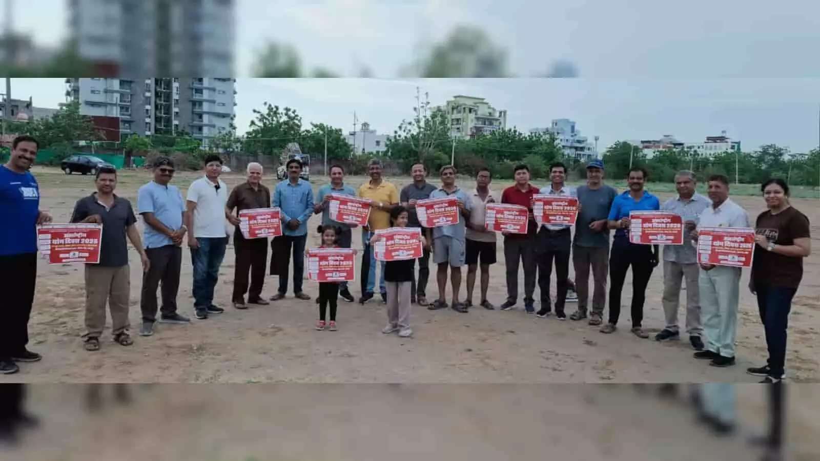 जयपुर के मैदान में अंतरराष्ट्रीय योग दिवस 2026 के पोस्टर के साथ खड़े पुरुष और बच्चे। जयपुर के मैदान में अंतरराष्ट्रीय योग दिवस 2026 के पोस्टर के साथ खड़े पुरुष और बच्चे।