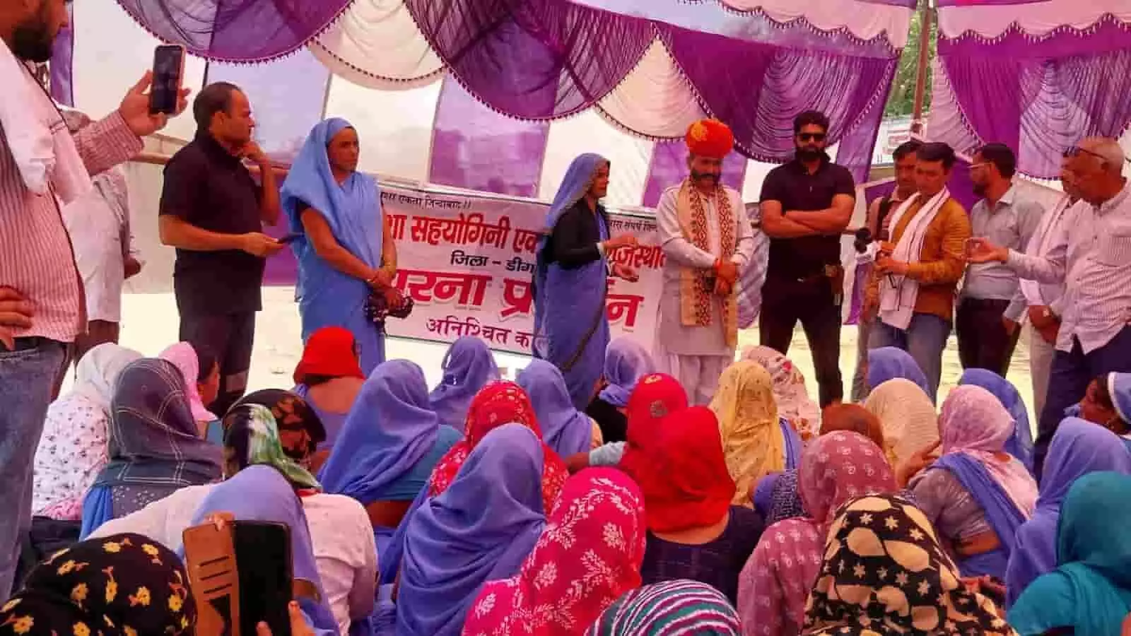 मेला मैदान में धरने पर बैठी आशा सहयोगिनियों को संबोधित करते किसान नेता नेम सिंह फौजदार मेला मैदान में धरने पर बैठी आशा सहयोगिनियों को संबोधित करते किसान नेता नेम सिंह फौजदार