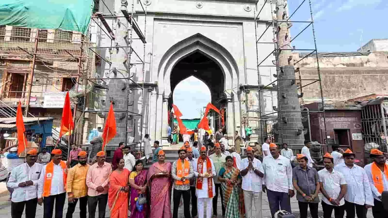 कोल्हापुर के अंबाबाई मंदिर के पास स्थापना दिवस पर भगवा ध्वज लेकर खड़े शिवसेना यूबीटी के कार्यकर्ता। कोल्हापुर के अंबाबाई मंदिर के पास स्थापना दिवस पर भगवा ध्वज लेकर खड़े शिवसेना यूबीटी के कार्यकर्ता।
