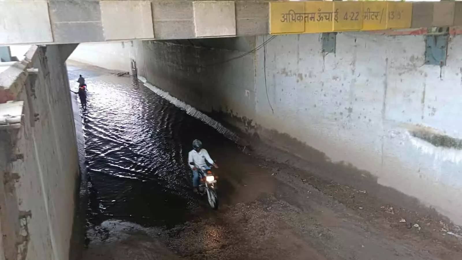 रेलवे पुलिया के नीचे भरा पानी और मोटरसाइकिल सवार राहगीर खेरोदा में जलभराव की समस्या। रेलवे पुलिया के नीचे भरा पानी और मोटरसाइकिल सवार राहगीर खेरोदा में जलभराव की समस्या।