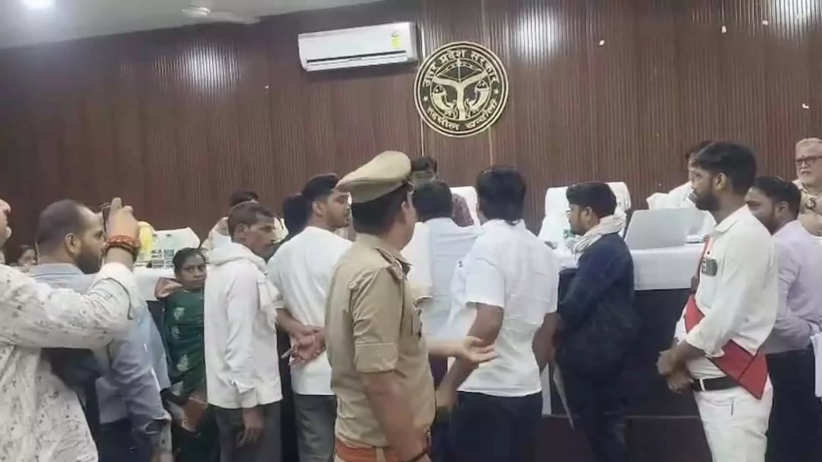 सरकारी कार्यालय परिसर में प्रशासनिक अधिकारियों के सामने अपनी शिकायत फाइल लेकर खड़ा एक पीड़ित व्यक्ति। सरकारी कार्यालय परिसर में प्रशासनिक अधिकारियों के सामने अपनी शिकायत फाइल लेकर खड़ा एक पीड़ित व्यक्ति।