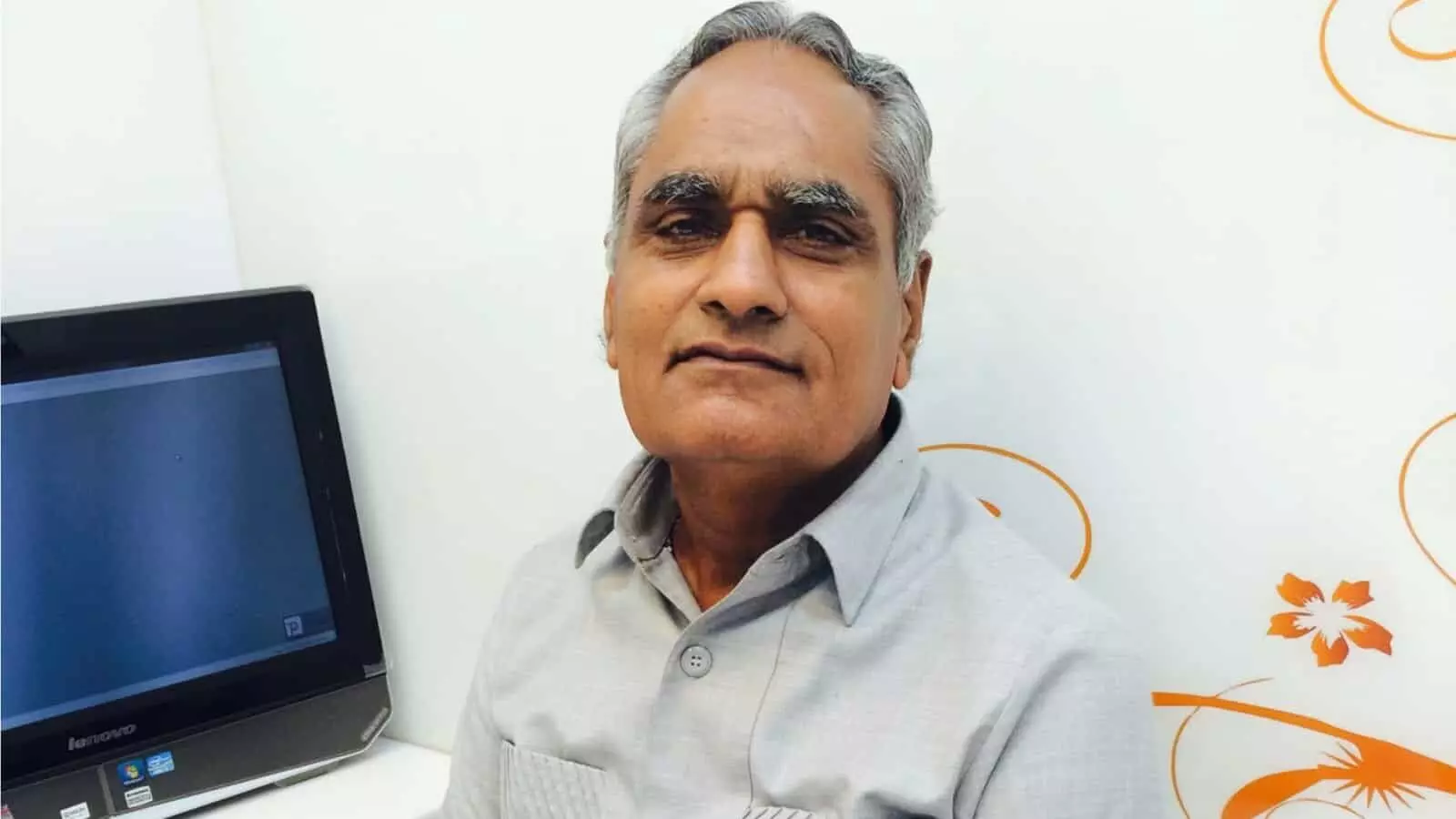 सफेद शर्ट पहने हुए समाजसेवी रोशनलाल पगारिया कंप्यूटर स्क्रीन के पास बैठे हुए नजर आ रहे हैं।