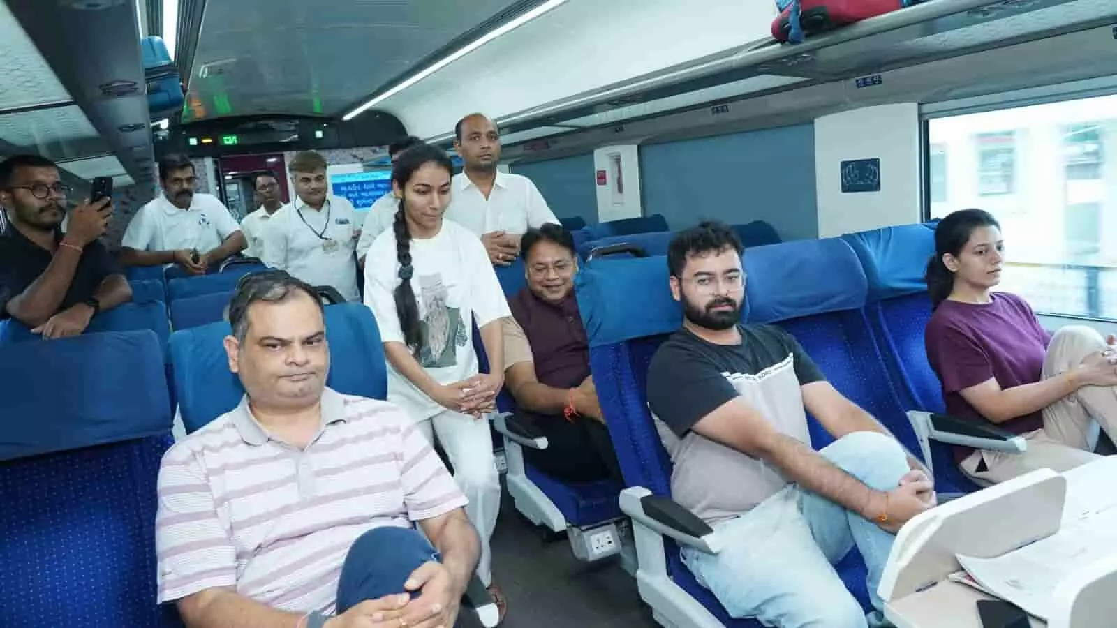 तस्वीर में यात्री अहमदाबाद मंडल की वंदे भारत ट्रेन में योग करते हुए।