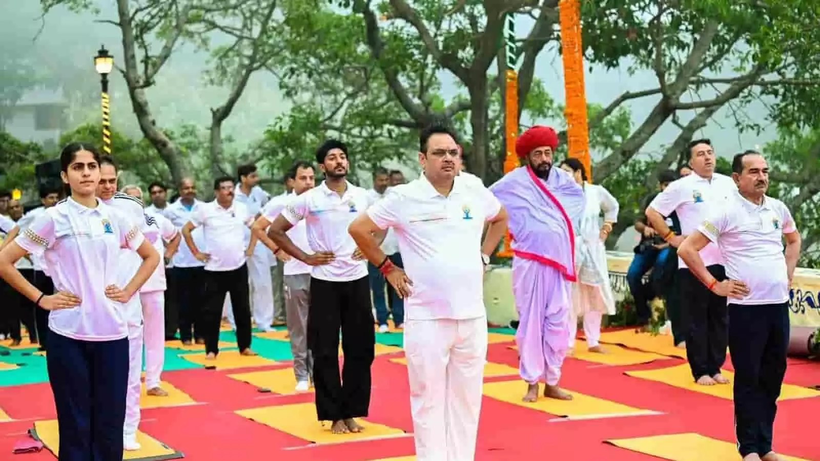 तस्वीर में मदन राठौड़ और अन्य लोग अंतरराष्ट्रीय योग दिवस पर अभ्यास करते दिख रहे हैं।
