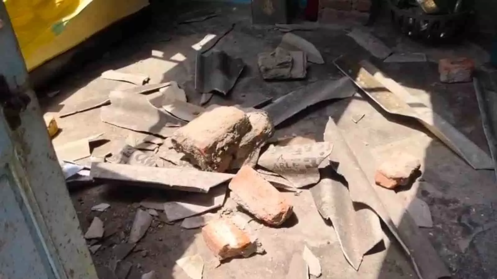 बालाजी खेड़ा कच्ची बस्ती में आंधी से ढहे कच्चे मकान की छत का बिखरा हुआ मलबा और ईंटें।