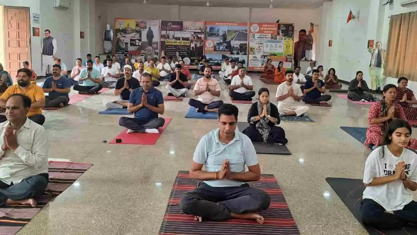 चटाई पर योग मुद्रा में बैठे भाजपा नेता और कार्यकर्ता भीलवाड़ा कार्यालय में योगाभ्यास के दौरान।