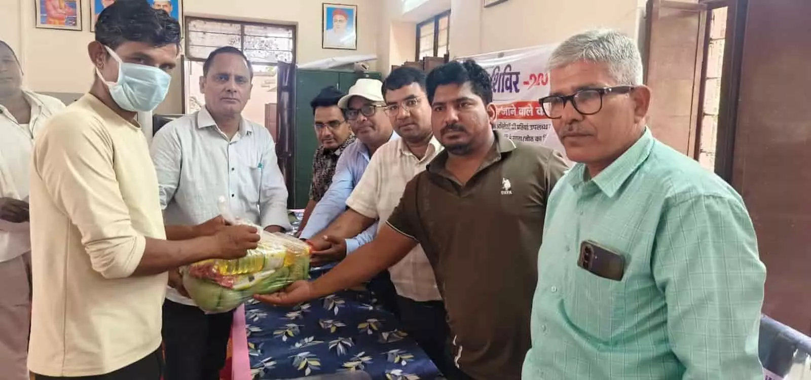 तस्वीर में ग्रामीण सेवा शिविर के दौरान अधिकारी और स्वास्थ्य कर्मी टीबी मरीज को पोषण किट सौंपते हुए दिख रहे हैं। तस्वीर में ग्रामीण सेवा शिविर के दौरान अधिकारी और स्वास्थ्य कर्मी टीबी मरीज को पोषण किट सौंपते हुए दिख रहे हैं।