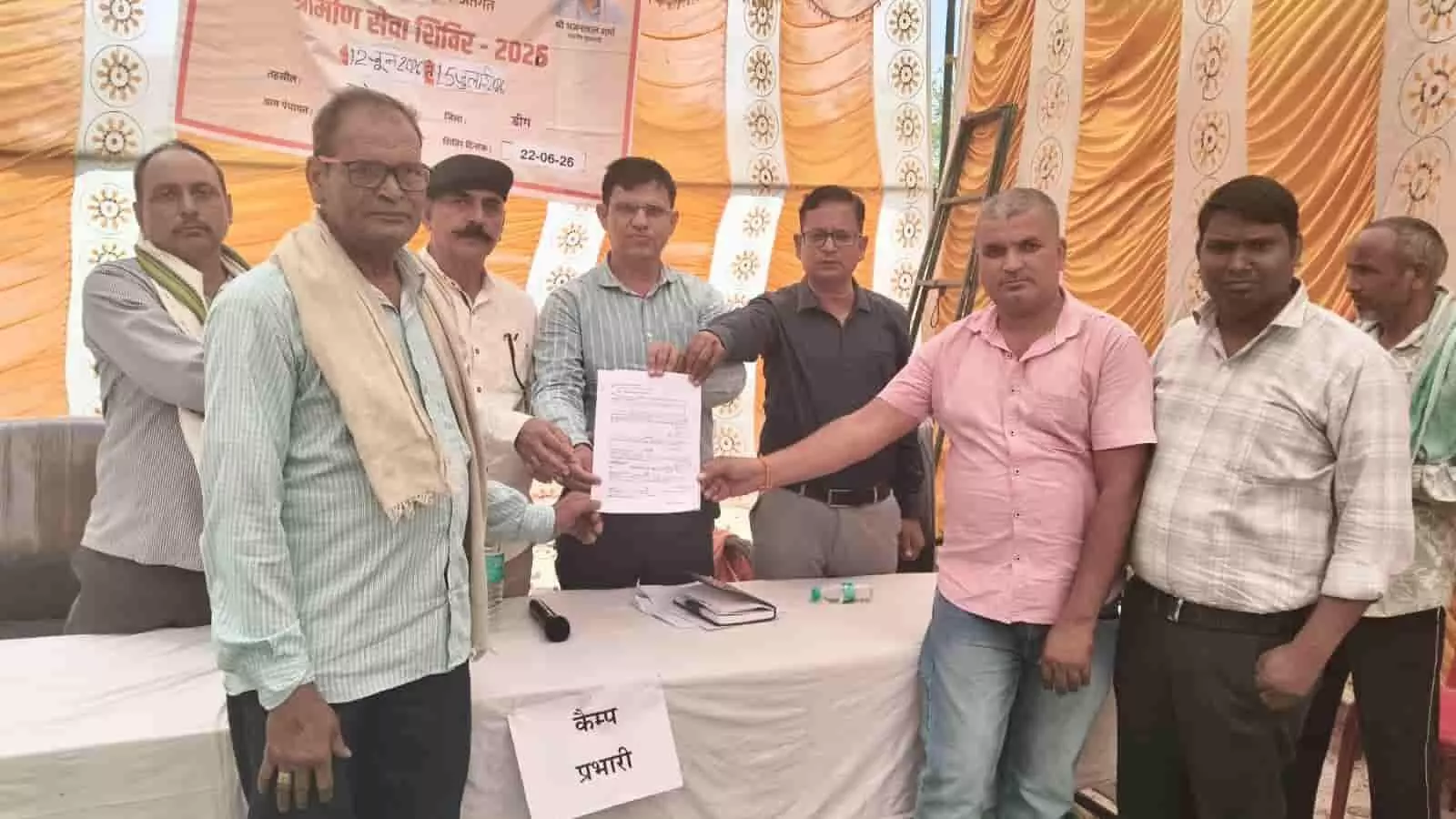 ग्रामीण सेवा शिविर में राजस्व अधिकारी और ग्रामीण ताखा में संशोधित भूमि दस्तावेज प्रदर्शित करते हुए। ग्रामीण सेवा शिविर में राजस्व अधिकारी और ग्रामीण ताखा में संशोधित भूमि दस्तावेज प्रदर्शित करते हुए।