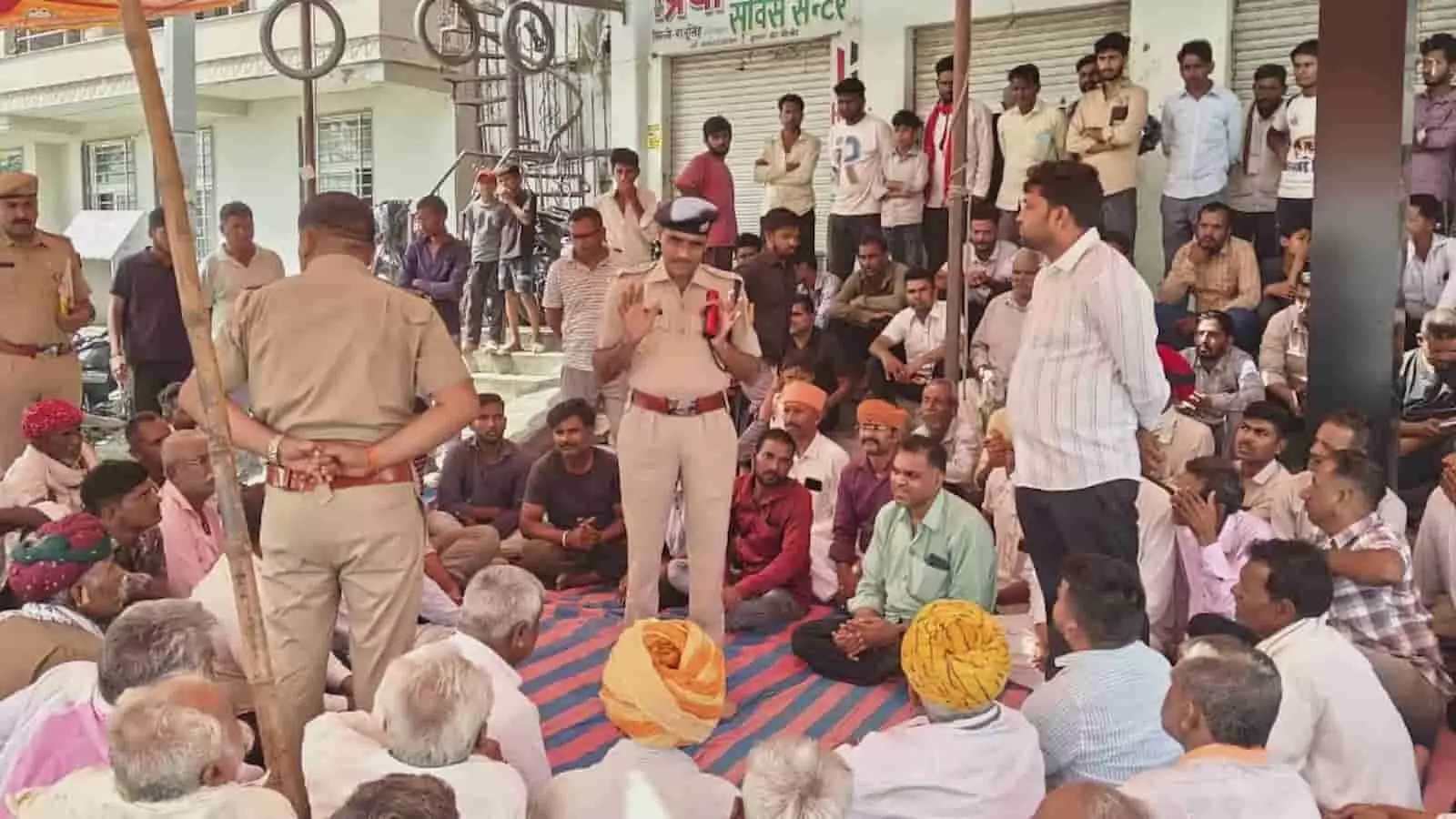 झाला की चौकी में फायरिंग के विरोध में पुलिस अधिकारियों से वार्ता करते ग्रामीण और व्यापारी। झाला की चौकी में फायरिंग के विरोध में पुलिस अधिकारियों से वार्ता करते ग्रामीण और व्यापारी।