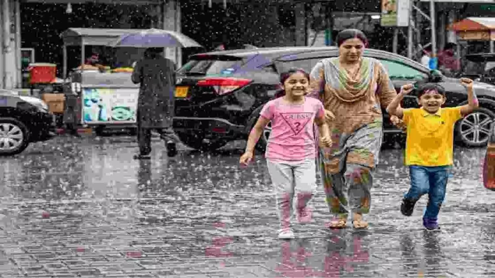 दिल्ली में बारिश के बीच सड़क पर चलते बच्चे और महिला| दिल्ली में बारिश के बीच सड़क पर चलते बच्चे और महिला|