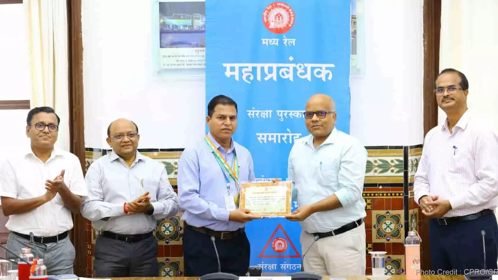 तस्वीर में मध्य रेलवे के अधिकारी रेलकर्मियों को सुरक्षा पुरस्कार देते हुए दिख रहे हैं।