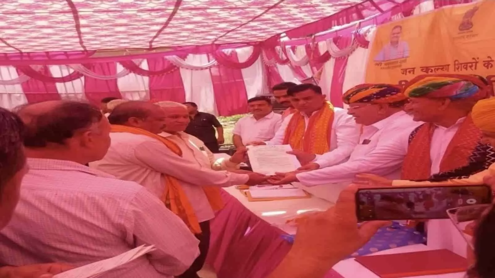 तस्वीर में ग्रामीण सेवा शिविर में अधिकारियों द्वारा भानपुर कलां में लाभार्थी को भूमि पट्टा सौंपते हुए दिख रहा है। तस्वीर में ग्रामीण सेवा शिविर में अधिकारियों द्वारा भानपुर कलां में लाभार्थी को भूमि पट्टा सौंपते हुए दिख रहा है।