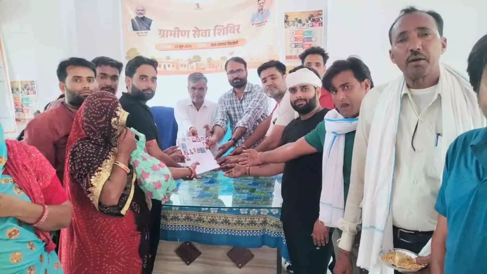 सिण्डोली ग्राम पंचायत के ग्रामीण सेवा शिविर में अधिकारी और ग्रामीण भूमि विवाद सुलझने के बाद दस्तावेज पकड़कर खड़े हैं।