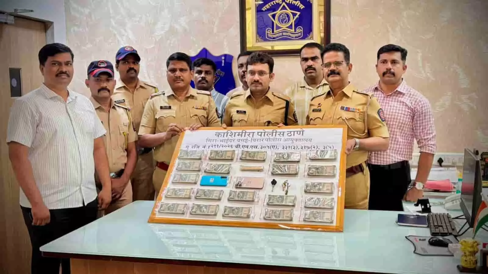 काशीमीरा पुलिस स्टेशन में मेज पर बरामद सामान के साथ खड़े पुलिस अधिकारी और जांच टीम।