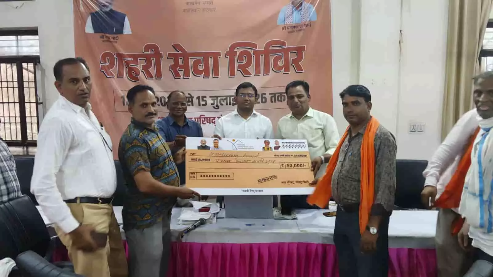 गंगापुर सिटी नगर परिषद सभागार में शहरी सेवा शिविर के दौरान लाभार्थियों को चेक सौंपते हुए प्रशासनिक अधिकारी। गंगापुर सिटी नगर परिषद सभागार में शहरी सेवा शिविर के दौरान लाभार्थियों को चेक सौंपते हुए प्रशासनिक अधिकारी।