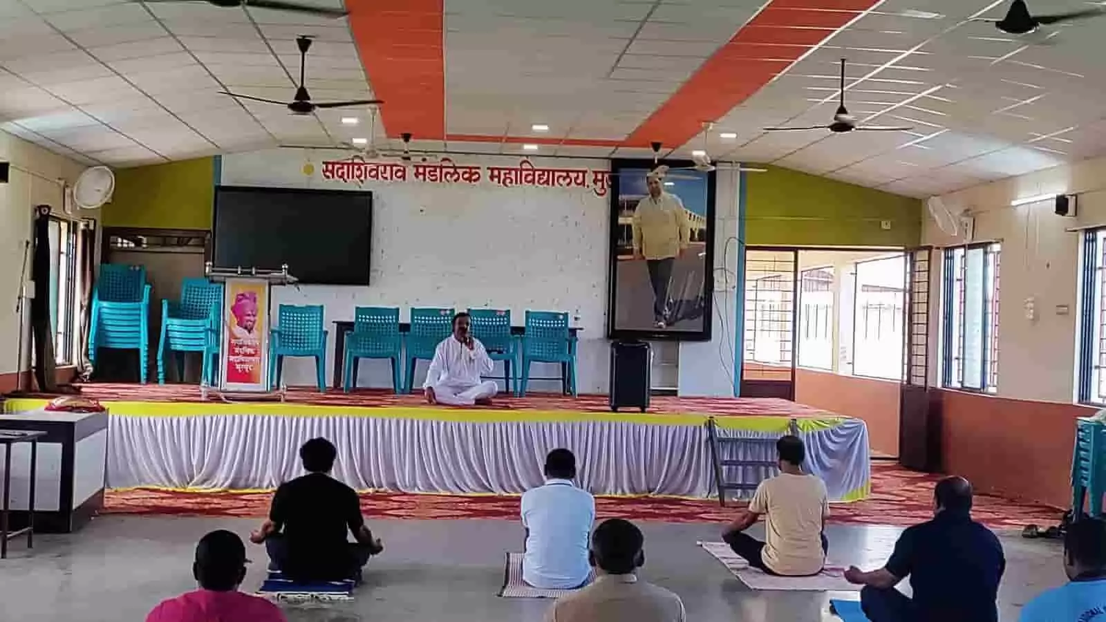 सदाशिवराव मंडलिक महाविद्यालय के सभागार में चटाई पर बैठकर योगाभ्यास करते लोग। सदाशिवराव मंडलिक महाविद्यालय के सभागार में चटाई पर बैठकर योगाभ्यास करते लोग।