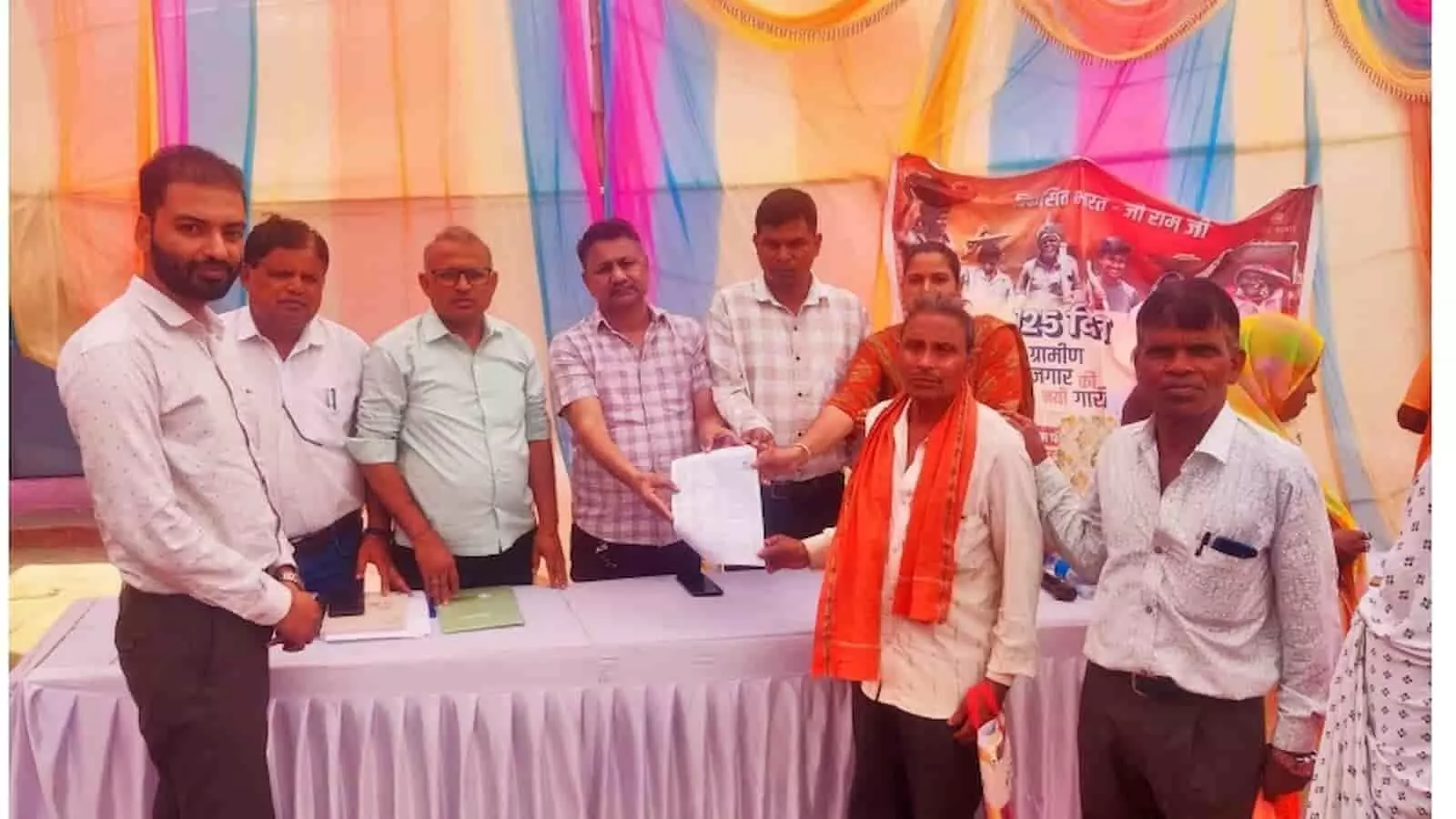 ढीकवास ग्राम पंचायत के सेवा शिविर में टेबल के पीछे खड़े अधिकारी और जनप्रतिनिधि एक वृद्ध को पेंशन स्वीकृति का पत्र सौंप रहे हैं। ढीकवास ग्राम पंचायत के सेवा शिविर में टेबल के पीछे खड़े अधिकारी और जनप्रतिनिधि एक वृद्ध को पेंशन स्वीकृति का पत्र सौंप रहे हैं।