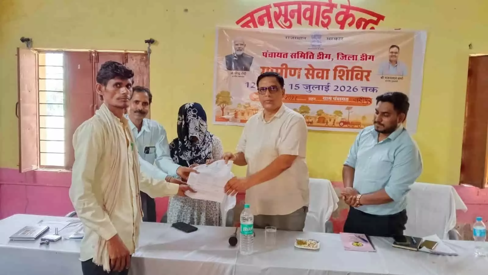 बद्रीपुर ग्राम पंचायत में आयोजित ग्रामीण सेवा शिविर में अधिकारी द्वारा आवेदक को जन्म प्रमाण पत्र सौंपने का दृश्य।