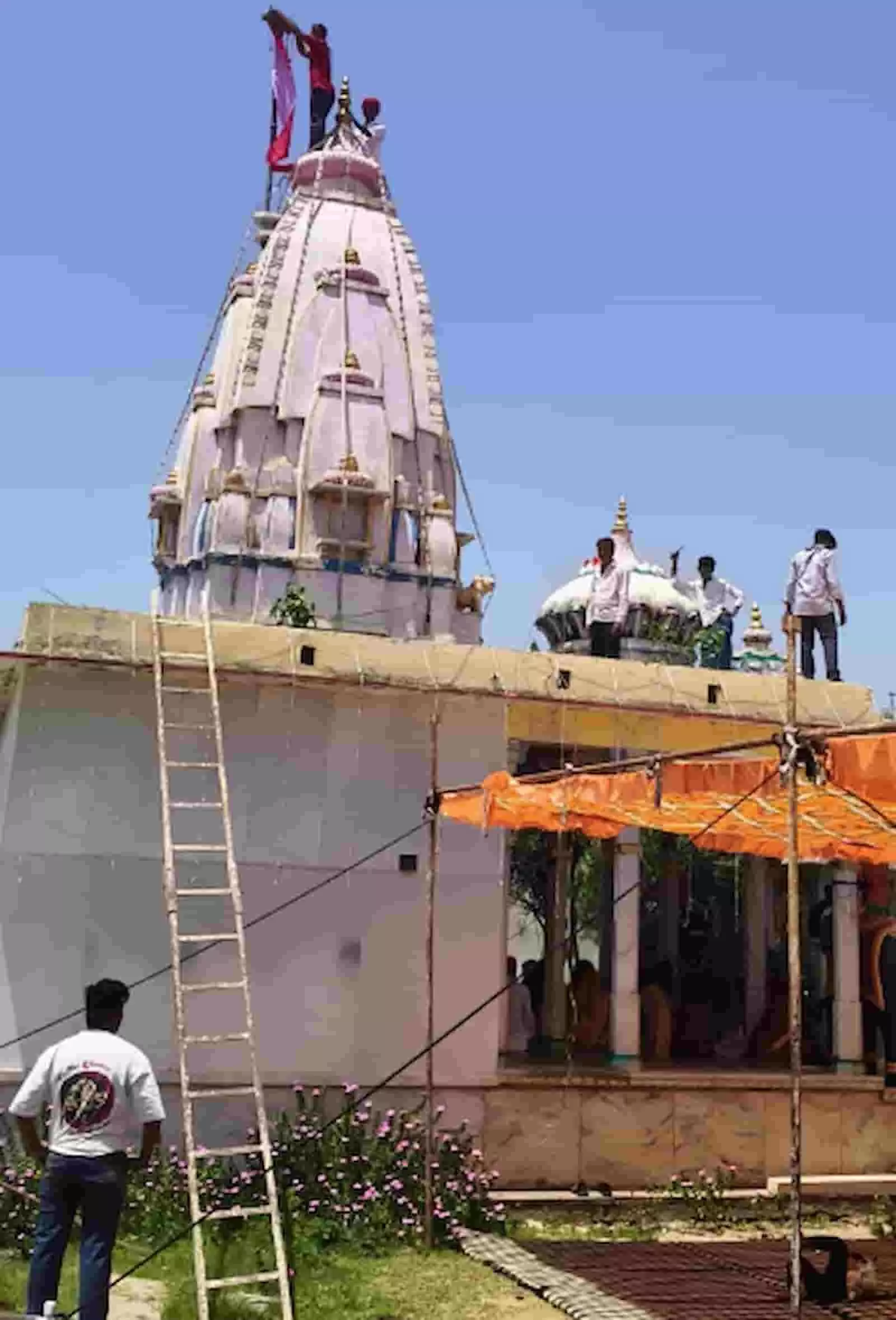 कोठेश्वर महादेव मंदिर के सफेद शिखर पर चढ़कर ध्वजारोहण करते लोग और नीचे खड़ा व्यक्ति। कोठेश्वर महादेव मंदिर के सफेद शिखर पर चढ़कर ध्वजारोहण करते लोग और नीचे खड़ा व्यक्ति।