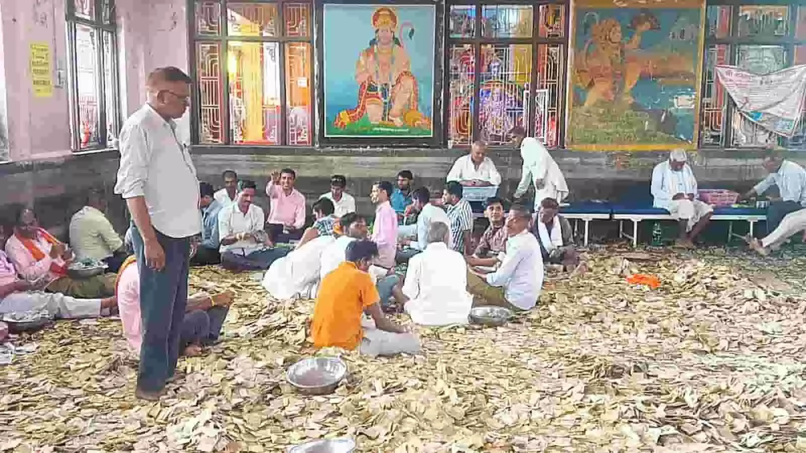 कामखेड़ा बालाजी मंदिर परिसर में बैठे लोग दान पेटी से निकली नकदी की गणना कर रहे हैं कामखेड़ा बालाजी मंदिर परिसर में बैठे लोग दान पेटी से निकली नकदी की गणना कर रहे हैं